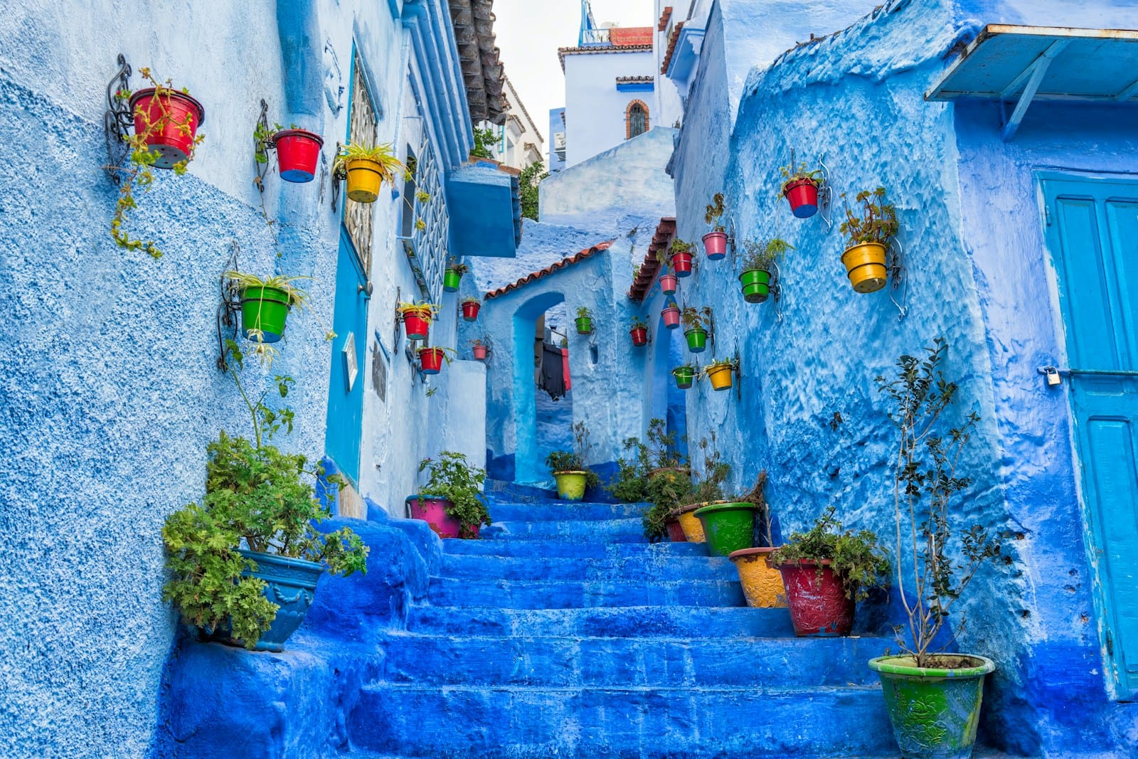 a narrow street with blue steps and potted plants,11 days tour from Casablanca