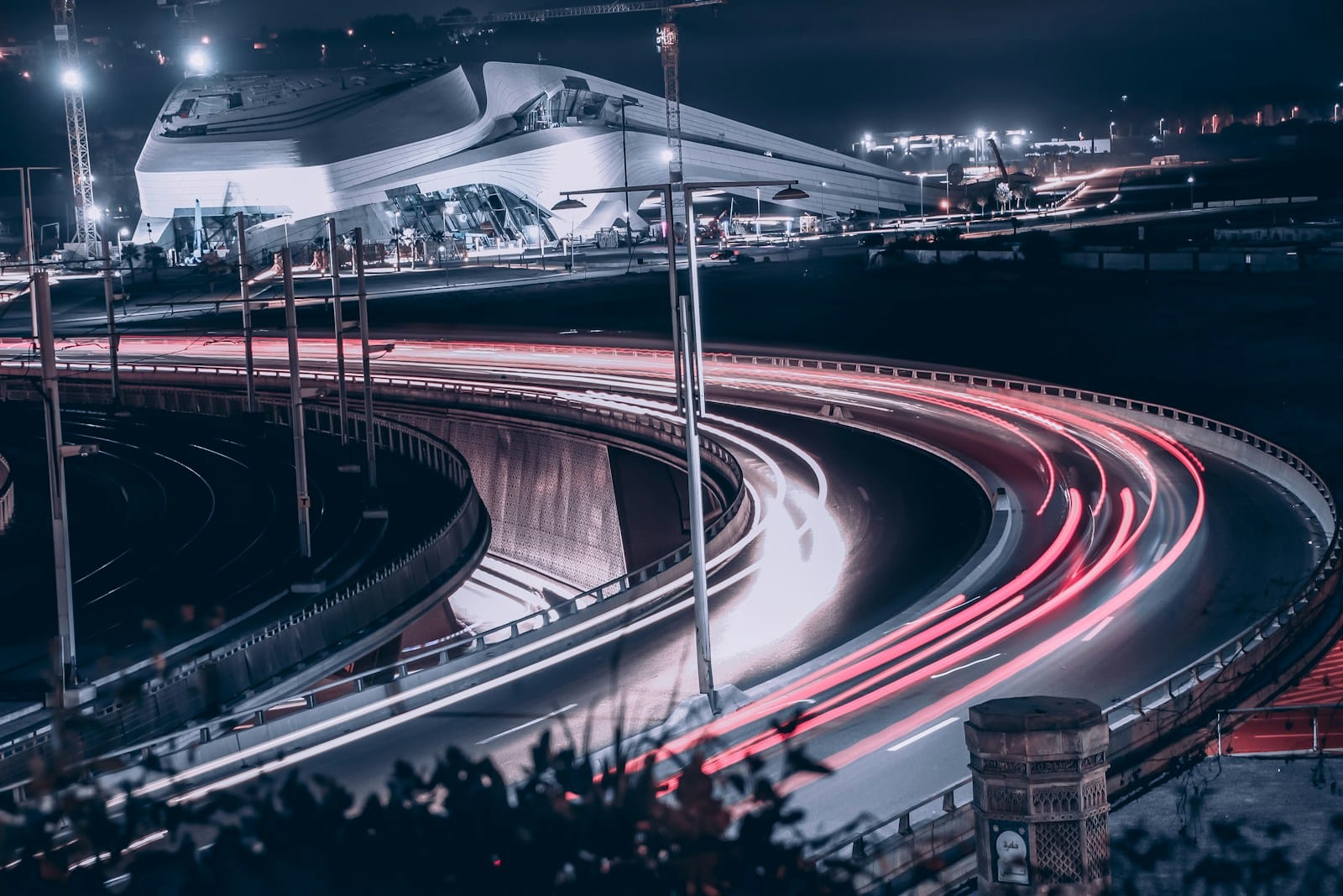 a night time view of a highway with a building in the background