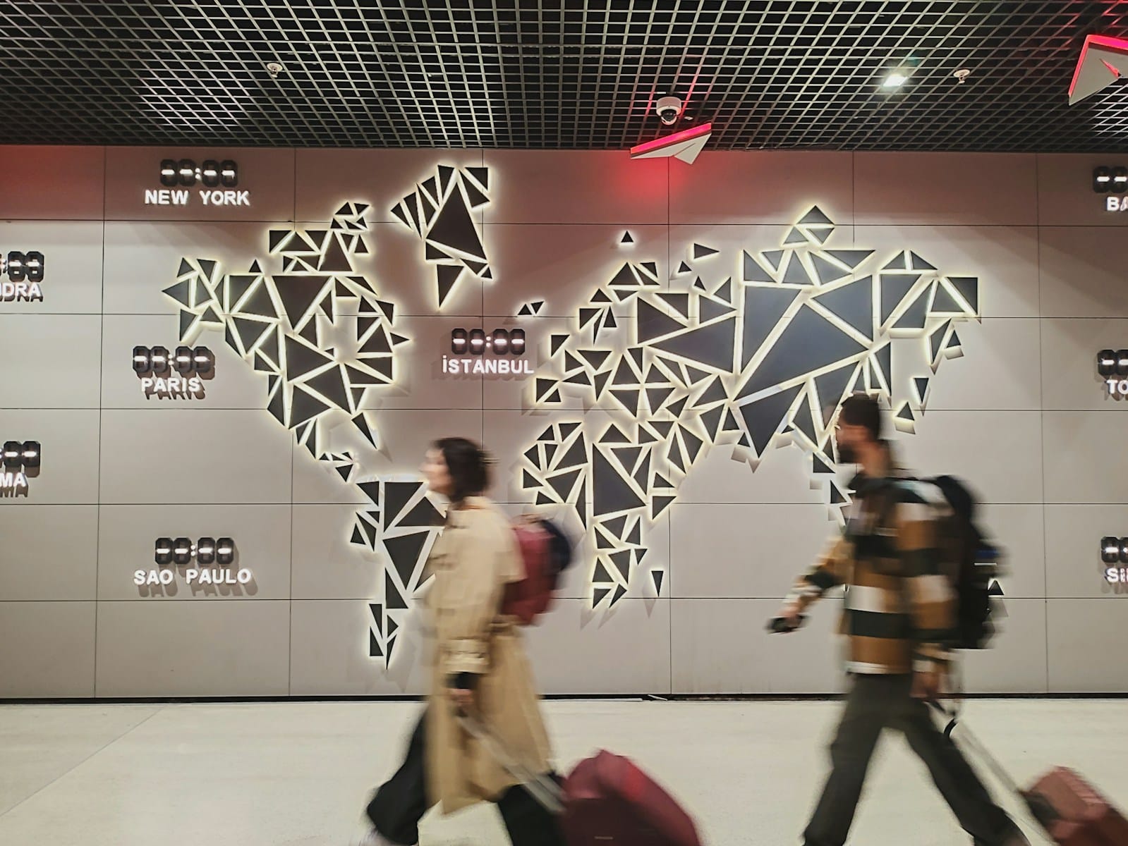 People walk past a glowing world map.Airports in Morocco,Major Airports