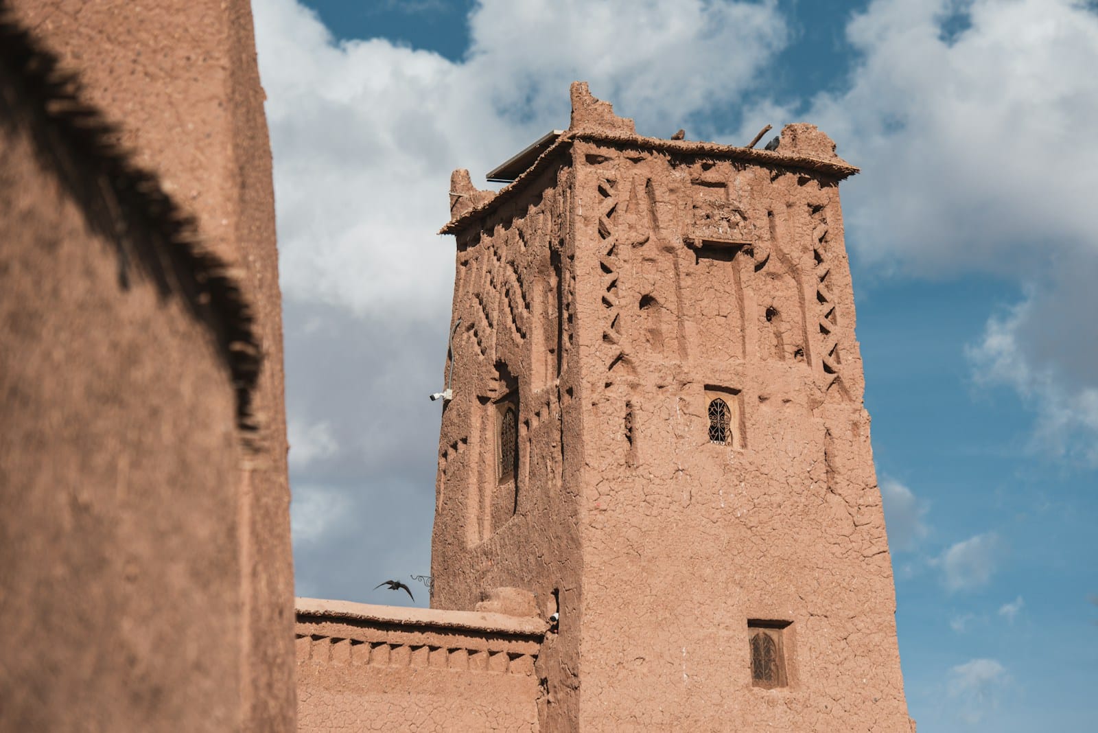 a tall brown building with a sky background,Ait Ben Haddou