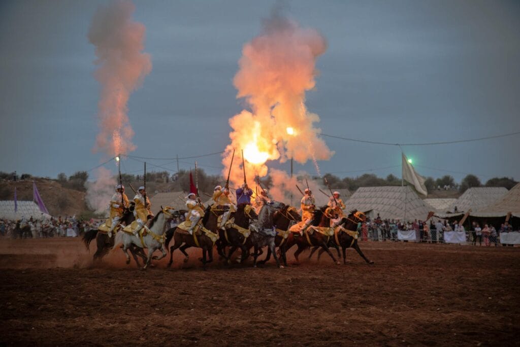 Horsemen perform traditional Fantasia display at Rabat festival with dramatic fireworks.Moroccan Heritage