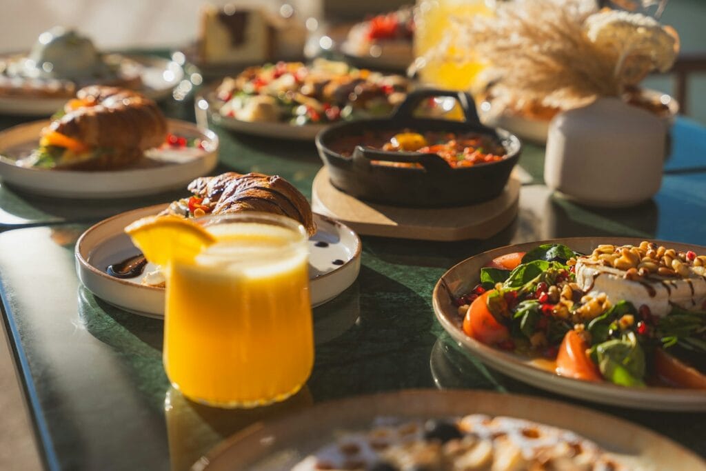 a table topped with plates of food and a glass of orange juice,Where and What to Eat in Morocco