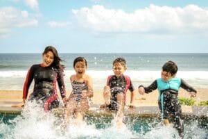A family having fun splashing water near the seashore on a sunny day in Bali, Indonesia.Morocco Family Friendly TourMorocco Family Friendly Tours