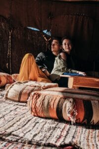 Young couple enjoying leisure time in a cozy Merzouga tent. Cultural and romantic atmosphere.Merzouga Weather in December