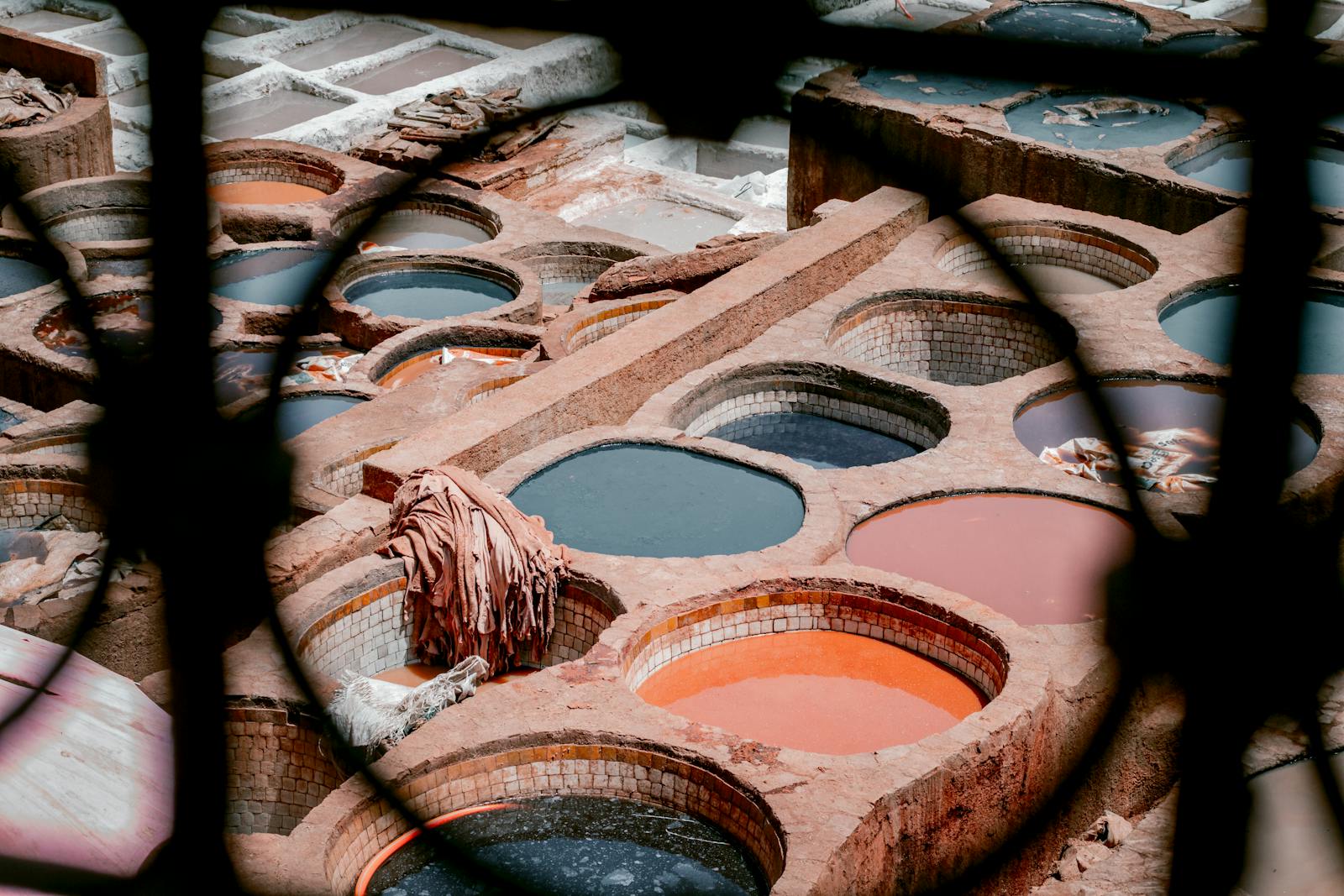 Aerial view of colorful dyeing vats in a traditional Moroccan leather tannery, vibrant textile scene.Chouara Tannery