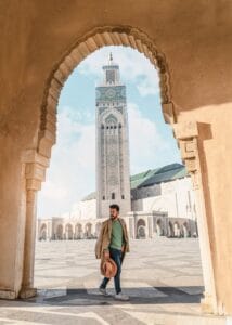 Man walking through archway with Hassan II Mosque minaret in Casablanca, Morocco.Hassan II Mosque