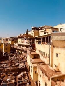 Historic tanneries in Fez under a clear blue sky, showcasing traditional dyeing vats.Chouara Tannery