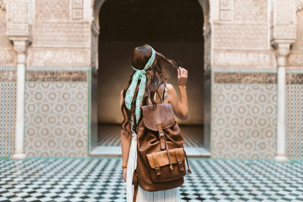 A woman in Marrakesh exploring the medina with a leather backpack, capturing the spirit of travel and adventure.temperatuur marokko februari