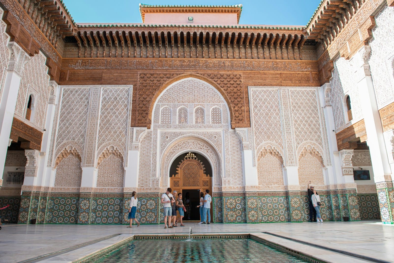 A group of people standing around a pool in a building,weather in morocco in may