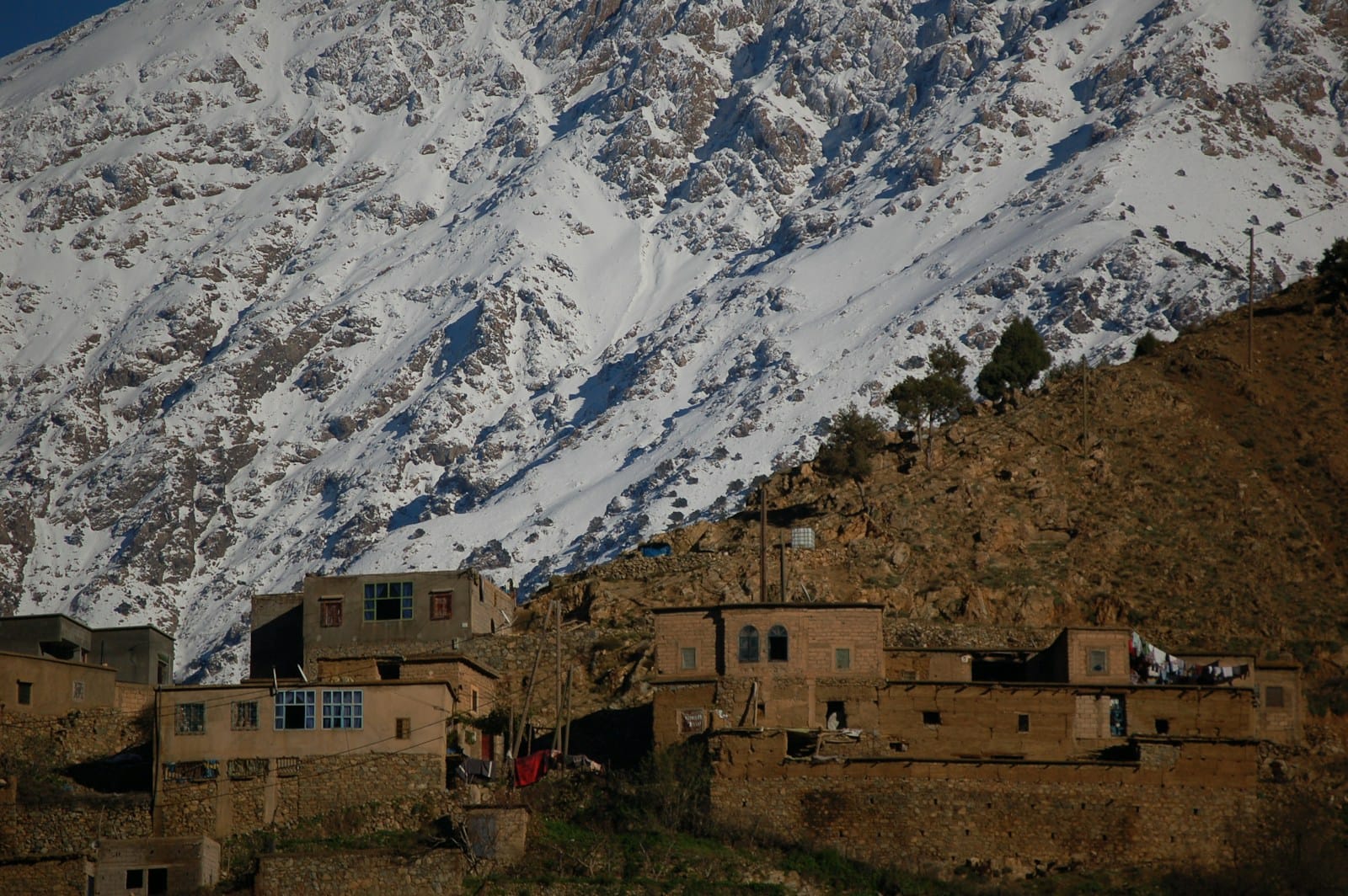 brown concrete building near snow covered mountain during daytime,Morocco Snow Fall Best Places