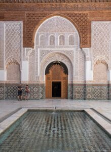 Two people standing in front of a building with a fountain.Morocco in July