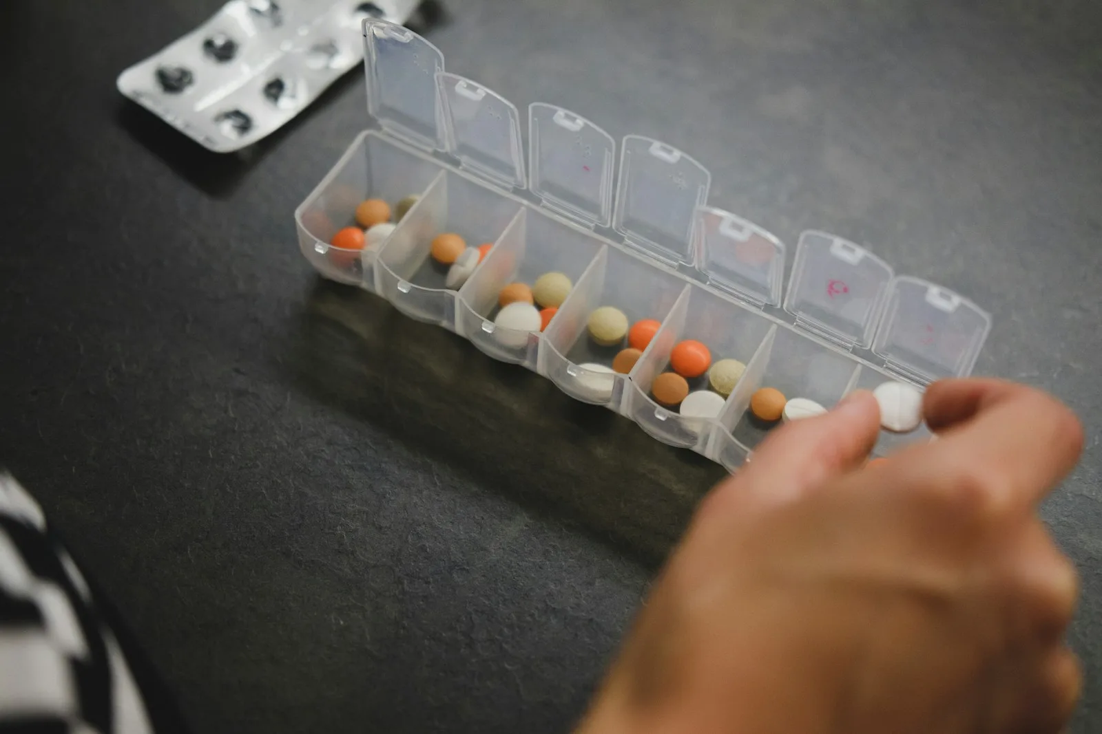 person about to pick medicine from medicine organizer.Medication in Morocco
