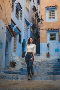 A woman poses in the iconic blue alleys of Chefchaouen, Morocco.Holiday in Morocco During Ramadan