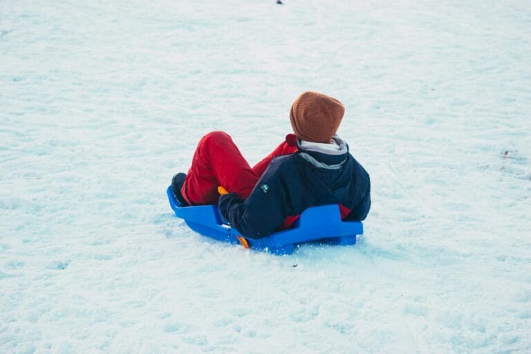 A person enjoys a wintry sledding adventure in the snowy landscapes of Oukaimeden, Morocco.