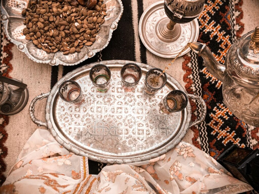 Elegant Moroccan tea setup on a decorative tray with almonds in Marrakesh, Morocco.tea in morocco