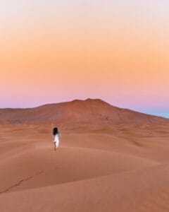 A lone traveler explores the stunning sand dunes of Al Wahat Al Dakhla at sunset.disrespectful in Morocco