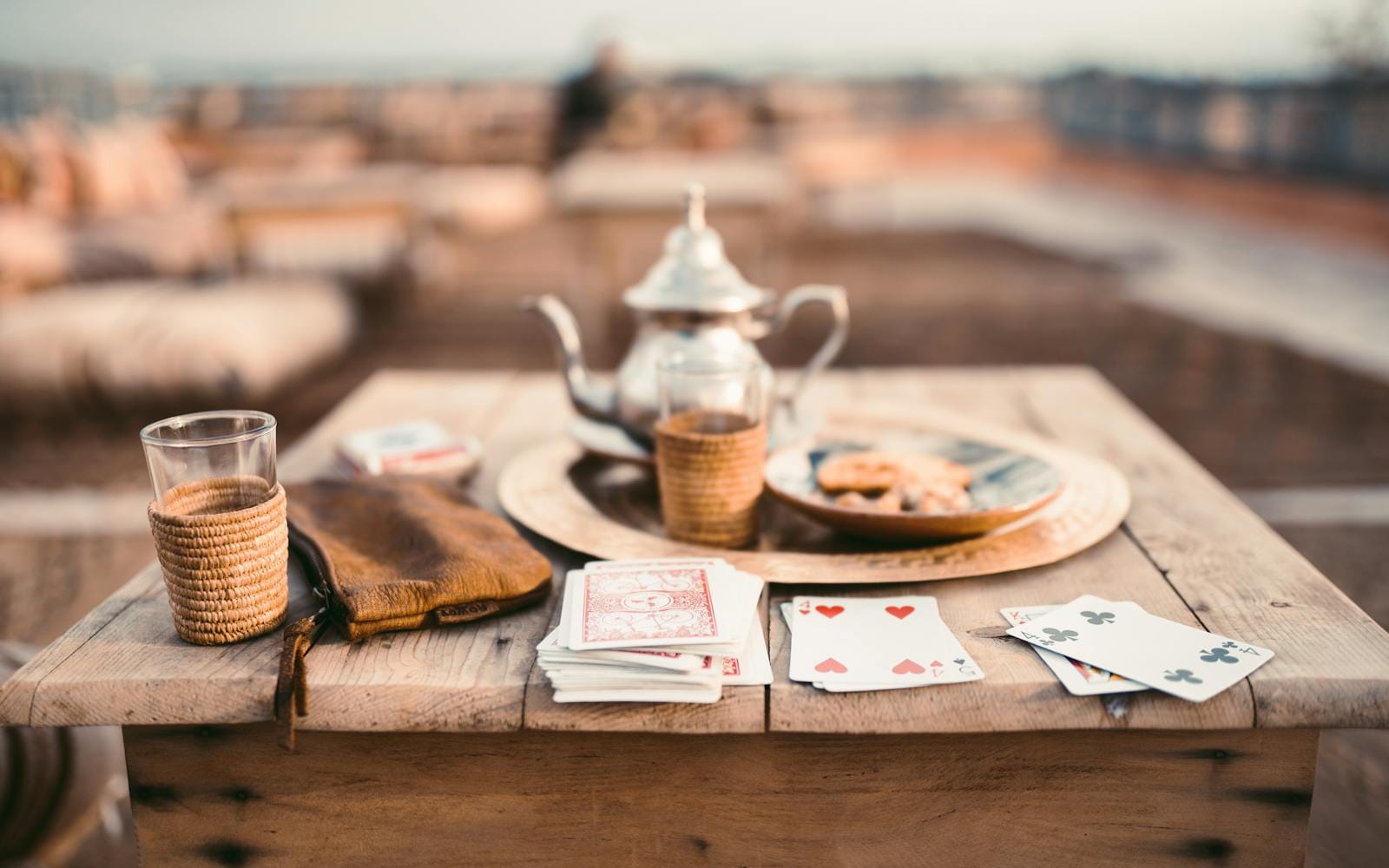 A warm scene of Moroccan tea and cards on a rooftop wooden table in Marrakesh.tea in morocco