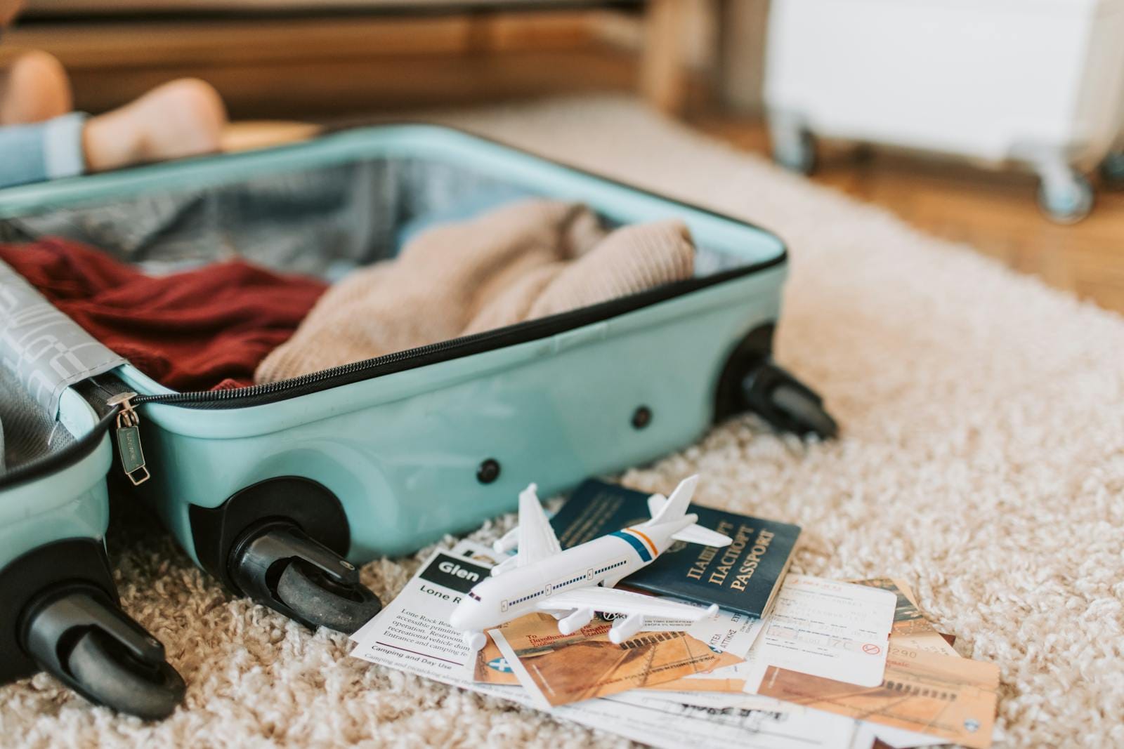 Close-up of an open suitcase with travel essentials like passport and tickets, ready for a journey.packing list