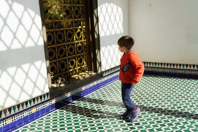 a little boy standing in a room with a tiled floor,marrakech with kids