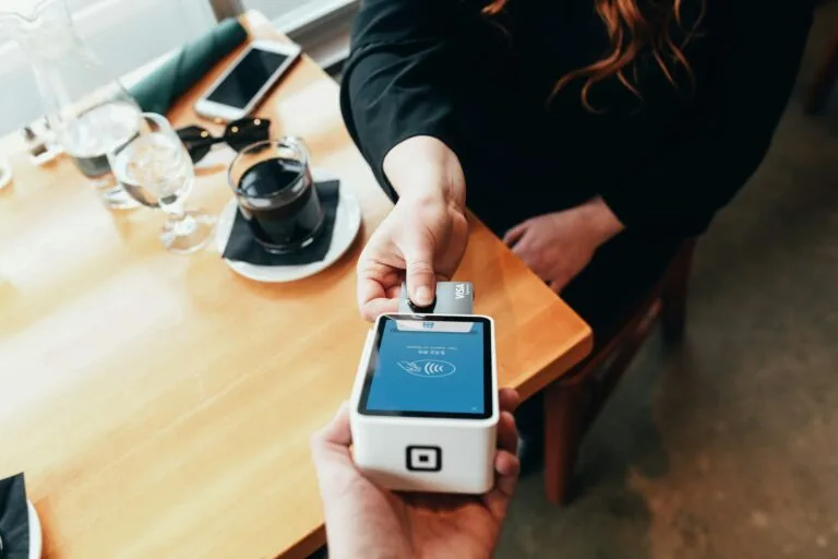 person holding credit card swipe machine.Tipping in .Do You Tip in Morocco