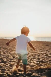 boy standing on sand near sea.Morocco with Family