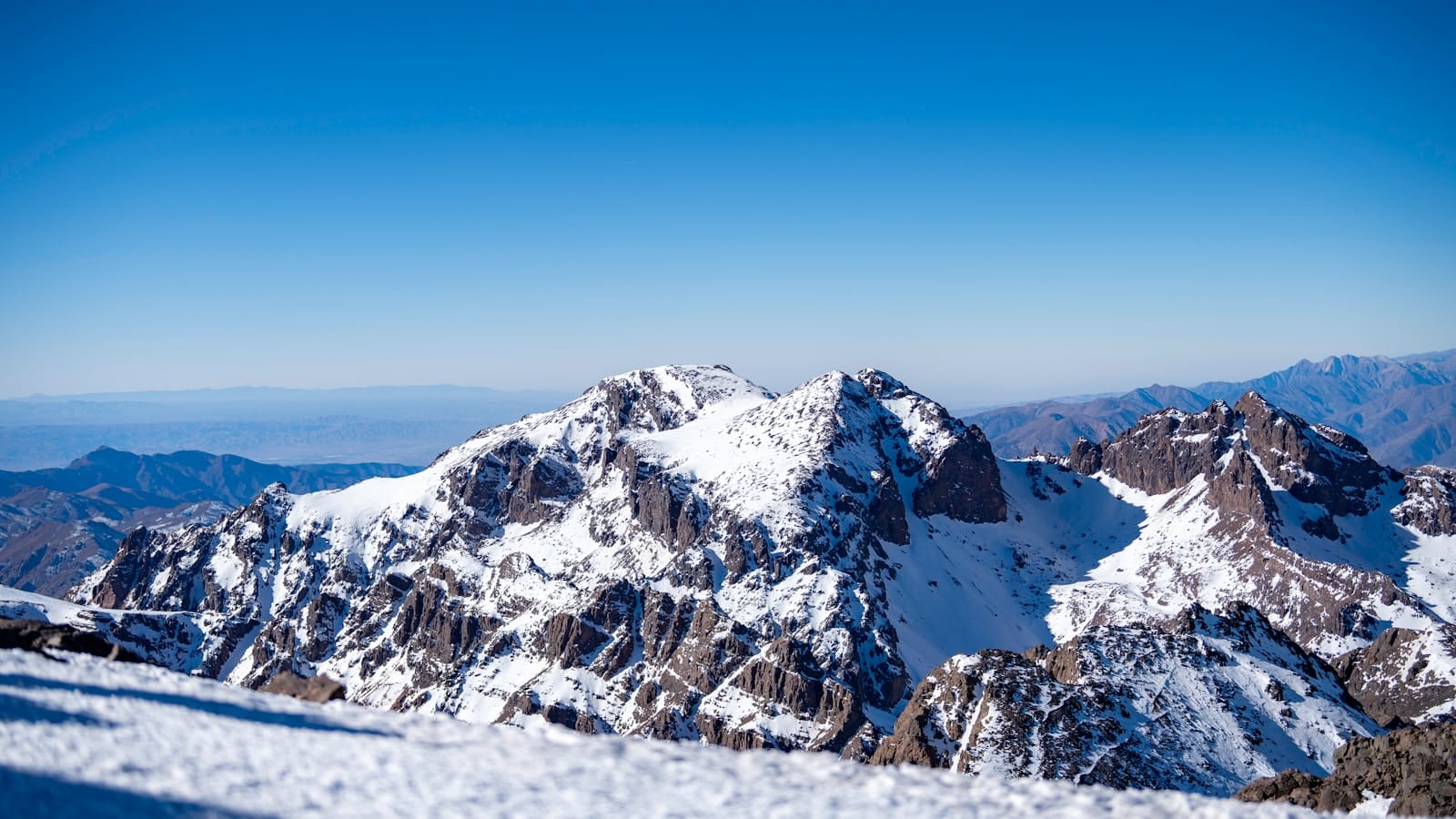 A snow covered mountain with a blue sky in the background