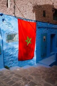 a blue building with a red flag hanging from it's side.Tipping in Morocco