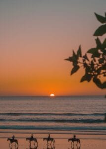 Riders silhouetted against a stunning sunset on a Moroccan beach.Agadir or Essaouira