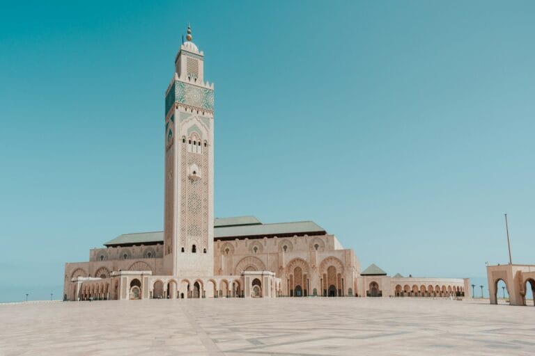 a large building with a tall tower with Hassan II Mosque in the background