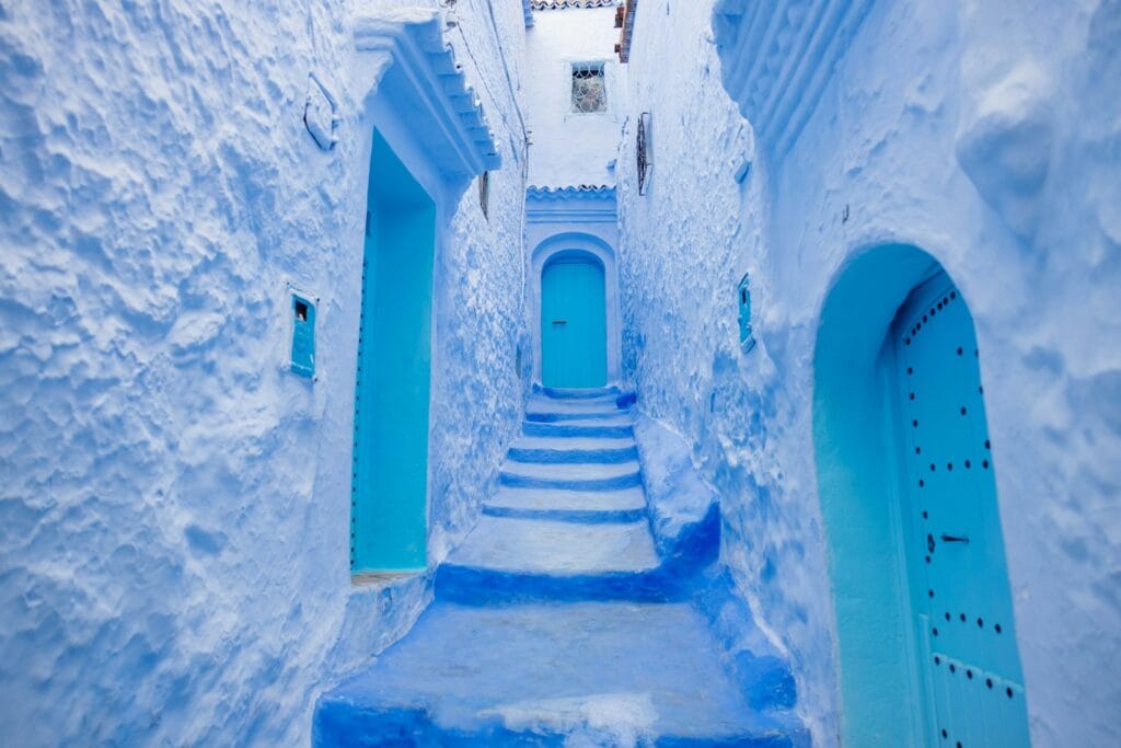 a narrow alley way with blue painted steps , What to Wear in Morocco in March