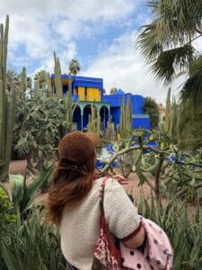 A woman admiring the vibrant plants at Majorelle Garden in Marrakech, Morocco.