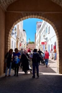 People walking through a vibrant street in the historic town of Essaouira, Morocco.