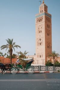 a horse drawn carriage in front of a tall tower.Weetjes Marokko