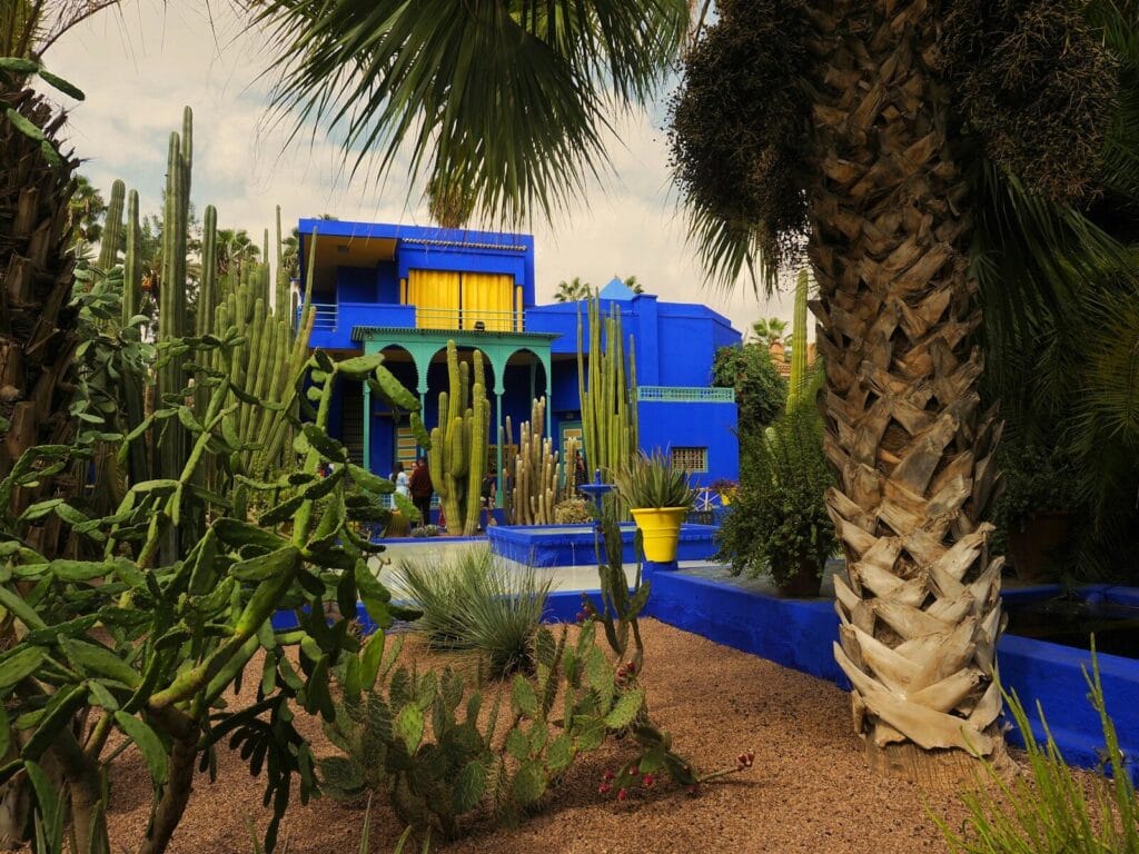 A blue and yellow building surrounded by palm trees