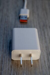 White power adapter and usb cable on wooden surface.plug