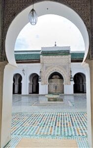 a building with a fountain in the middle of it.Fes to Marrakech