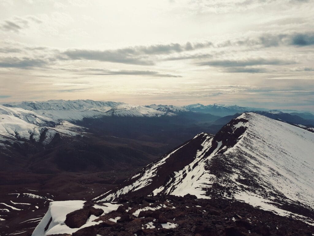 a view of a snowy mountain range from the top of a mountain.Atlas Mountains from Marrakech