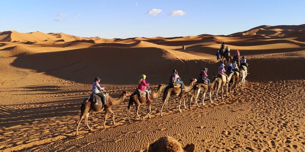 people riding camels on desert during daytime.Why is Erg Chebbi Famous