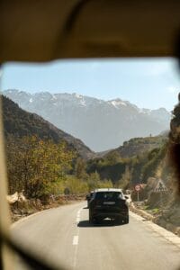A car drives through mountains on a sunny day.Atlas Mountains from Marrakech