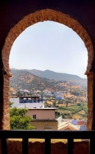a view of a city from a window in a building.Atlas Mountains from Marrakech