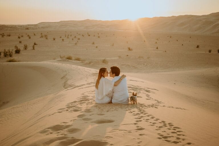 couple sitting on sand during daytime.morocco honeymoon