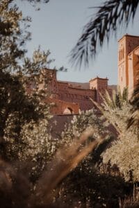 Explore the historic Ksar of Ait-Ben-Haddou surrounded by lush palm trees under the summer sun.Ouarzazate Skoura