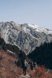 Group of hikers trekking through a rugged mountain landscape, experiencing nature's beauty.