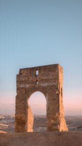 Stunning vertical shot of the ancient Marinid Tombs in Fes, Morocco at sunset, showcasing historical architecture.