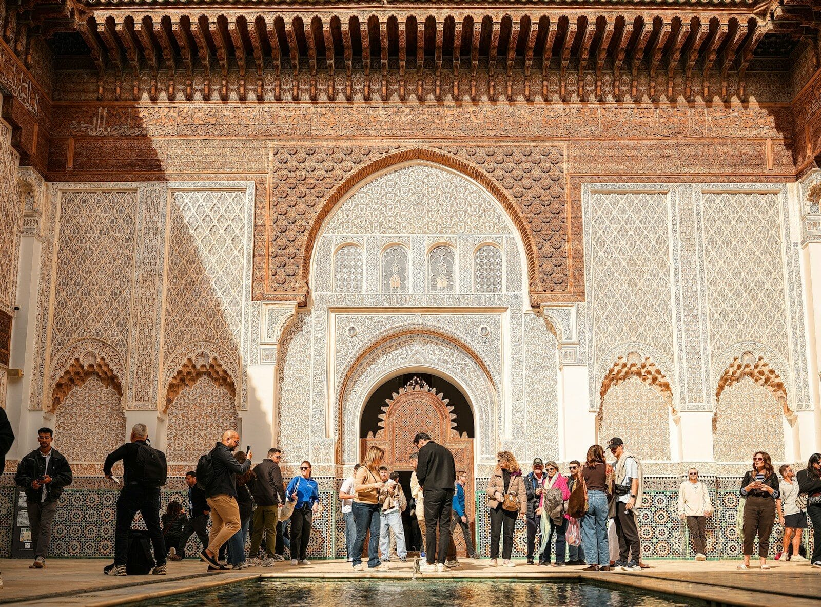 People gathered in a courtyard with ornate architecture.is Morocco safe for women