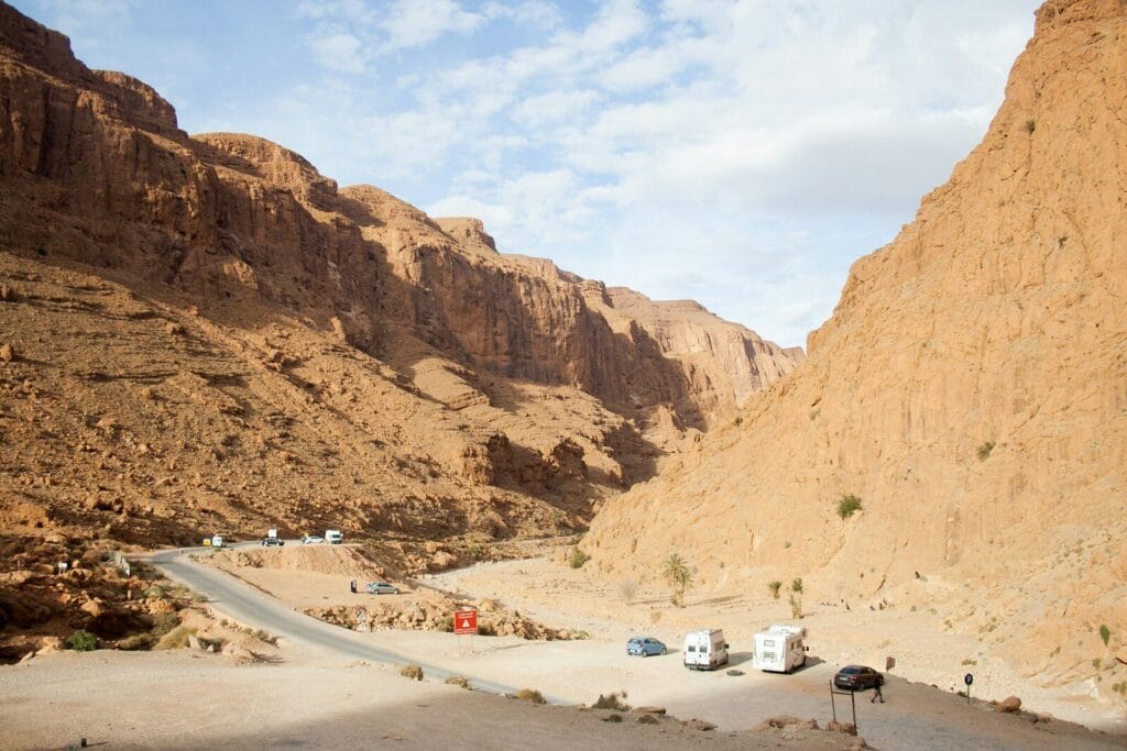 A road in the middle of a desert with mountains in the background.Todra Gorge