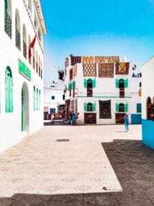 Colorful street scene in Asilah, Morocco showcasing vibrant building facades.is Asilah safe