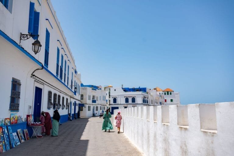 Charming view of people walking along a white and blue street in a Mediterranean town.Is Asilah Worth Visiting for Families