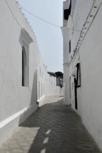 Narrow whitewashed alley in Asilah, Morocco, showcasing traditional architecture.What to do in Asilah with kids?