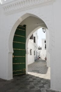 Explore the stunning architecture of Asilah, Morocco with this image of a traditional green archway.is Asilah safe
